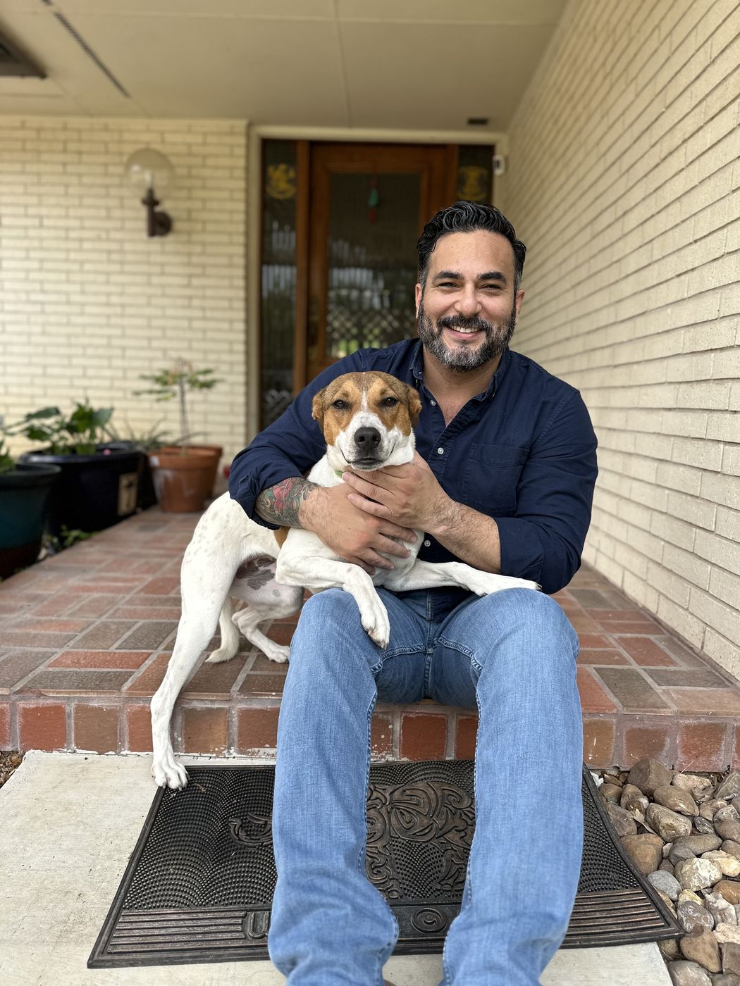 Dr. Jeremy Roberts sitting on his front step with his dog